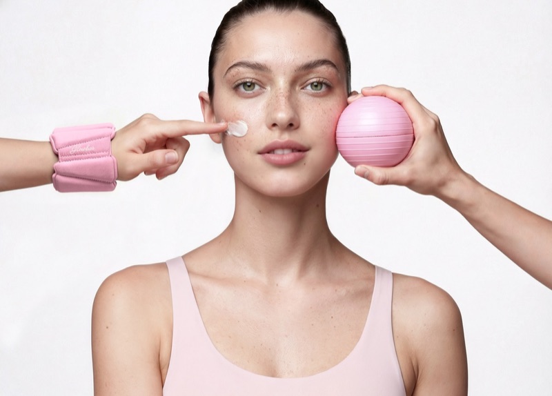GlowBar campaign photo: pink weighted wristband and massage ball, glowing skin